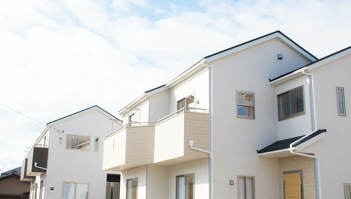 青空の下に建つ白を基調とした新築の戸建て住宅が並ぶ街並み